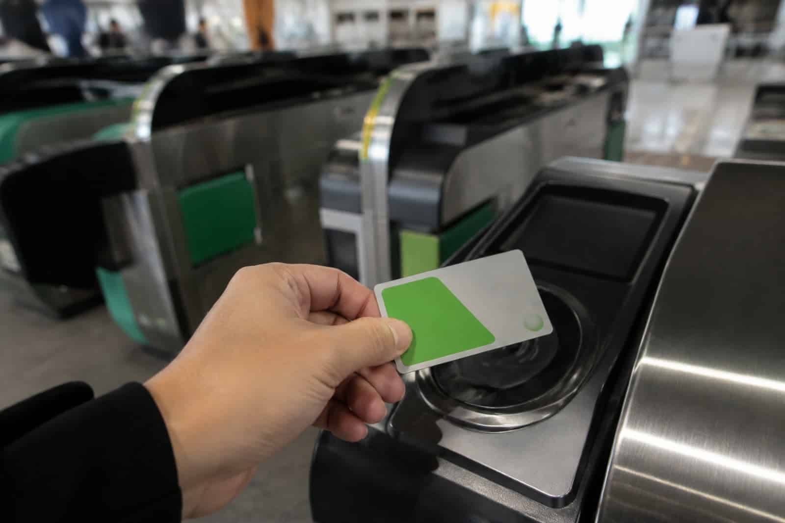 יד מקרבת כרטיס IC ירוק לקורא בשער כניסה לרכבת ביפן